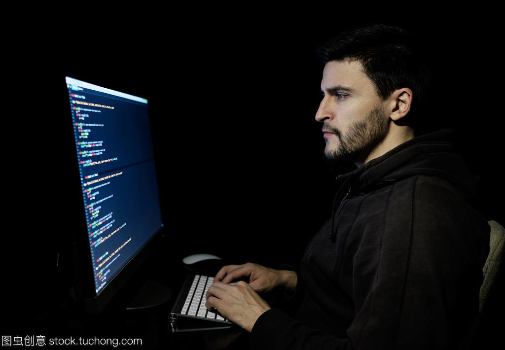 軟件開(kāi)發(fā)人員在黑暗家庭辦公室中的計(jì)算機(jī)軟件研發(fā)